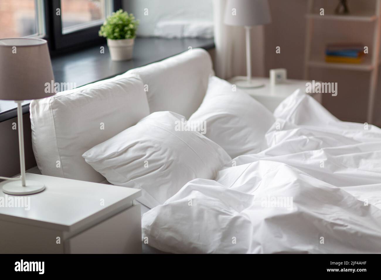 cozy bedroom with white linen on bed Stock Photo - Alamy