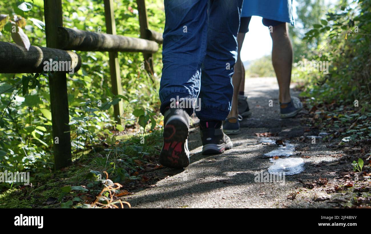 Unterwegs in der Natur. Mann und Frau mit Wanderschuhen unterwegs. Entlang eines Holzgeländers. Bild: RedCircles Media priv. Stock Photo