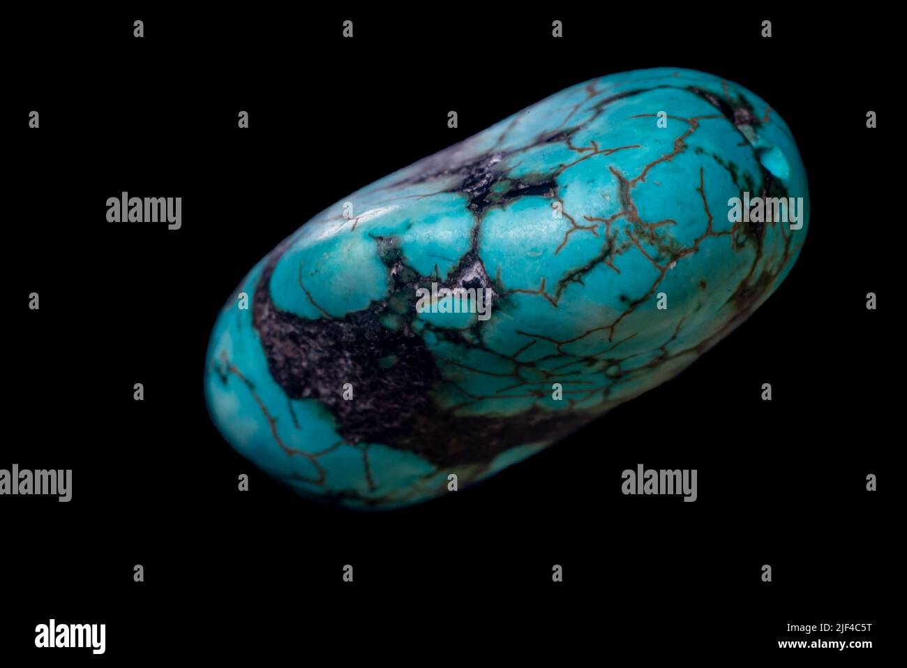 Raw turquoise gemstone rock isolated on a black background. Stock Photo