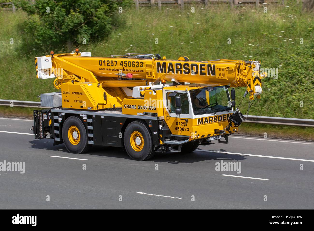 Marsdens Crane Hire, Contract Lifting 2021 Liebherr Ltm1040-2.1 Yellow 6700cc Diesel mobile crane; traveling on the M61 motorway near Manchester, UK Stock Photo