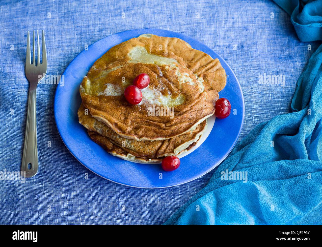 Stack of banana Pancakes with melted butter glaze and cherries as