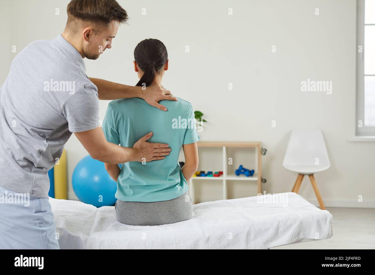 Osteopathic medicine and physiotherapy. Osteopath examining woman's back in in modern hospital office, closeup. Stock Photo