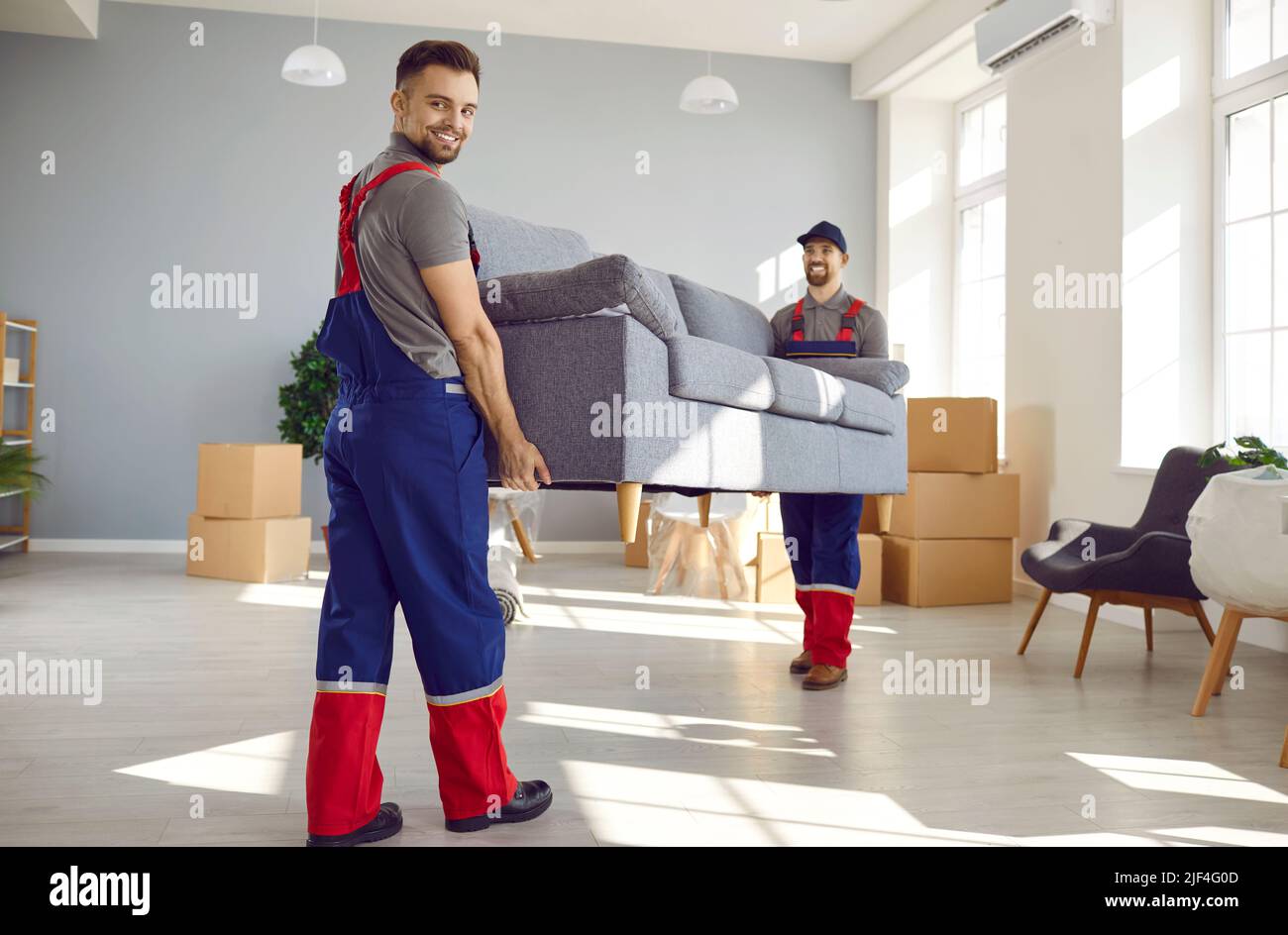 Two happy young workers from moving company and delivery service ...