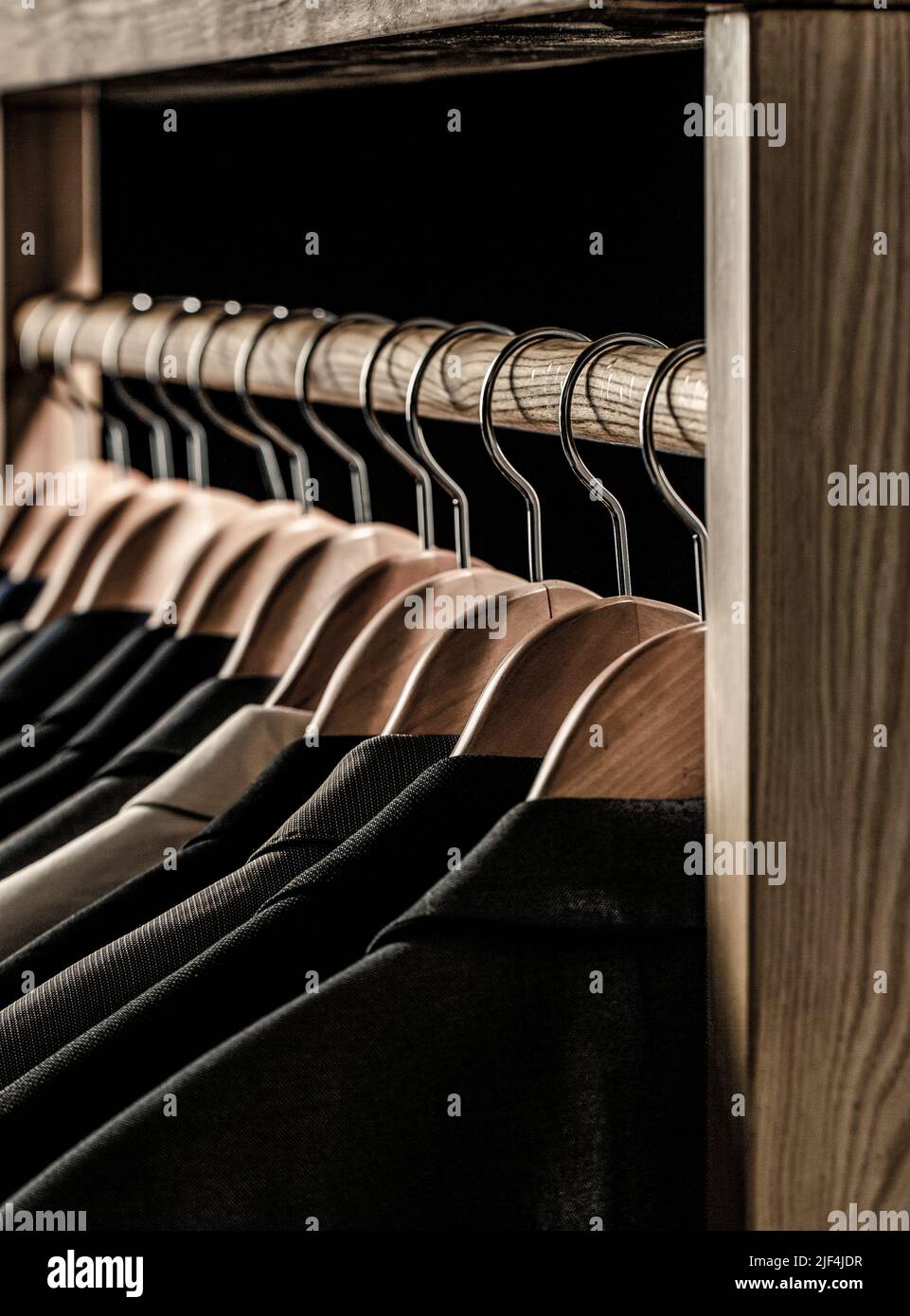 Mens shirts, suit hanging on rack. Hangers with jackets on them in