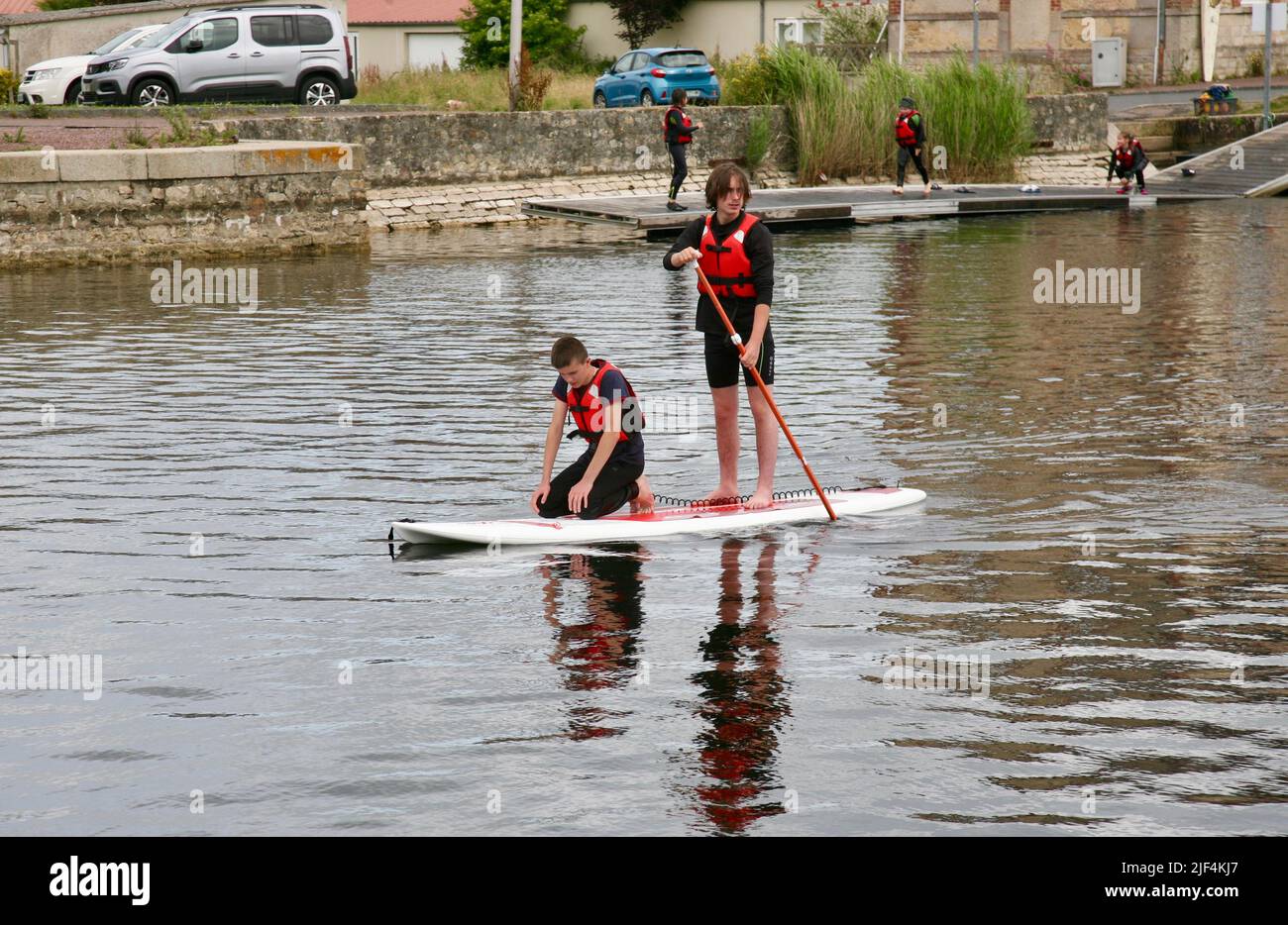 Two young men on a paddle board Stock Photo - Alamy