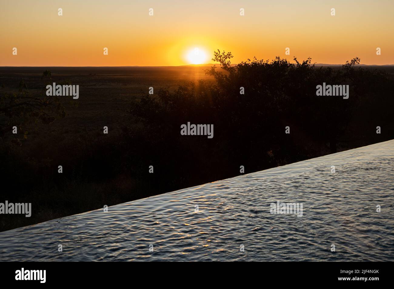 Sunset over an infinity pool Stock Photo
