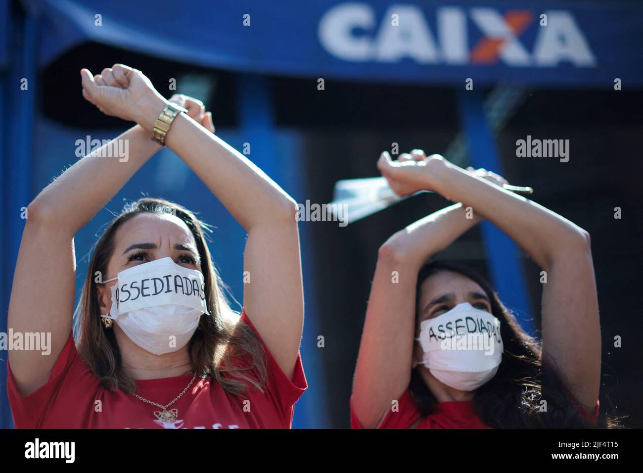 Employees of Caixa Economica Federal bank wear stickers over their mouths, reading 'Harassment', during a protest against the bank's president Pedro Guimaraes after allegations of sexual harassment, outside the bank's headquarters in Brasilia, Brazil June 29, 2022. REUTERS/Ueslei Marcelino Stock Photo