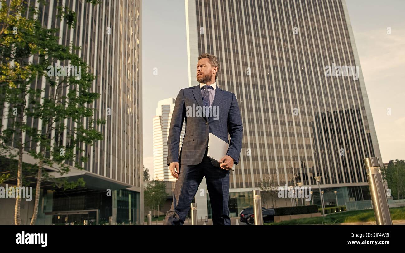 confident businessman outside the office. business success. manager man hold pc. Stock Photo