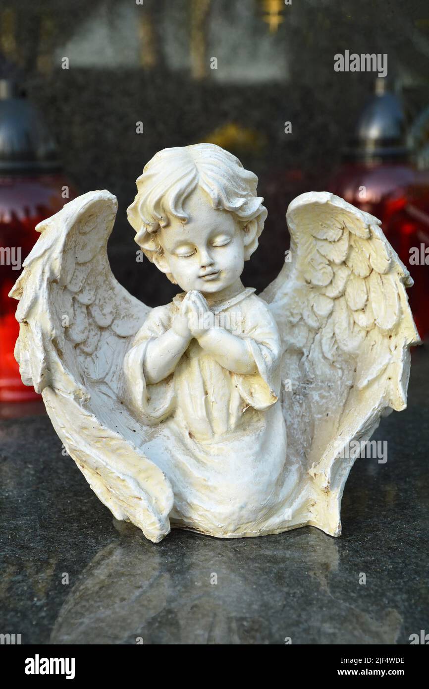 Angel figurine kneeling on the grave Stock Photo