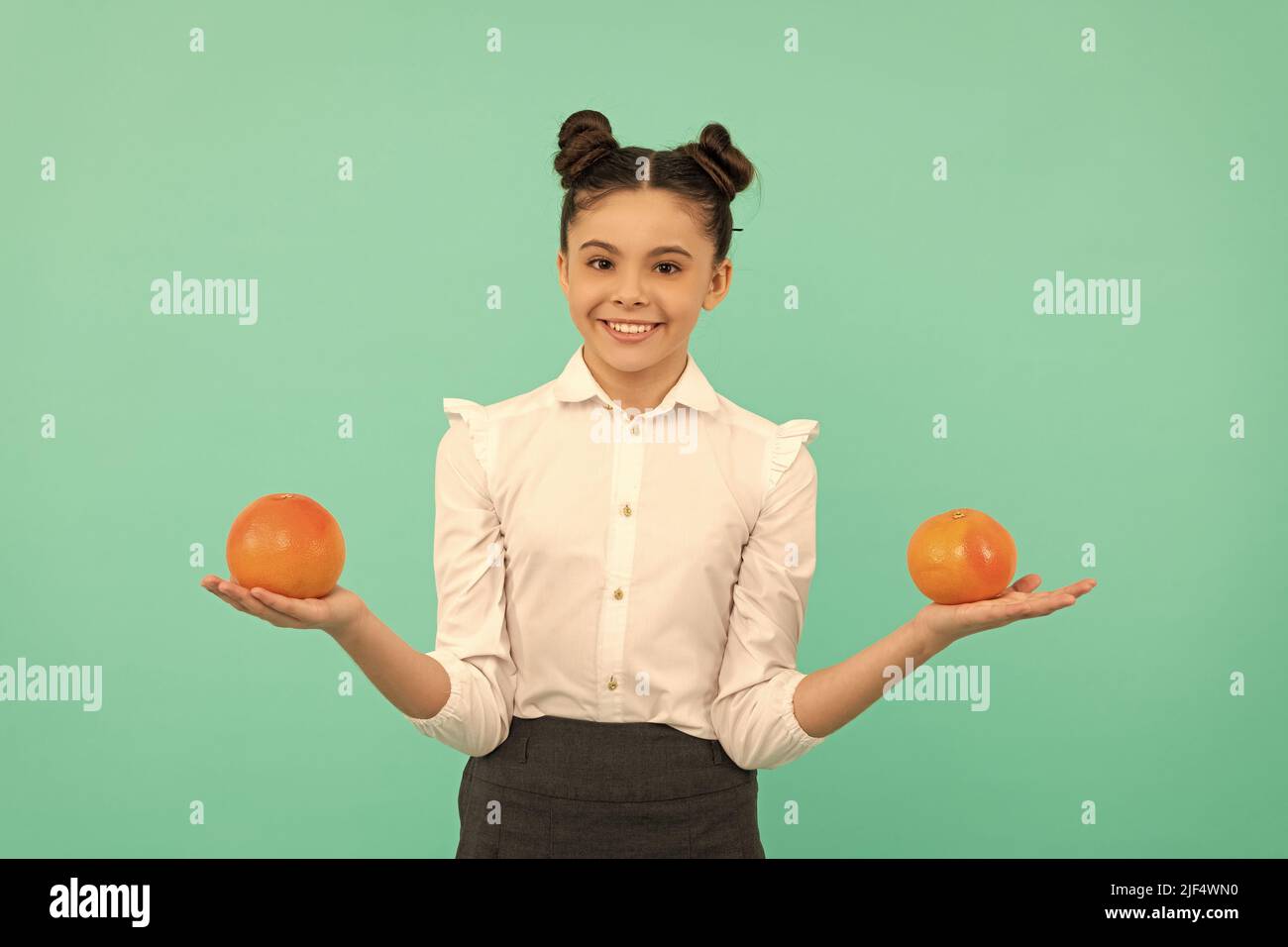 happy teen girl with grapefruit citrus fruit. vitamin and dieting. child eating healthy food. Stock Photo