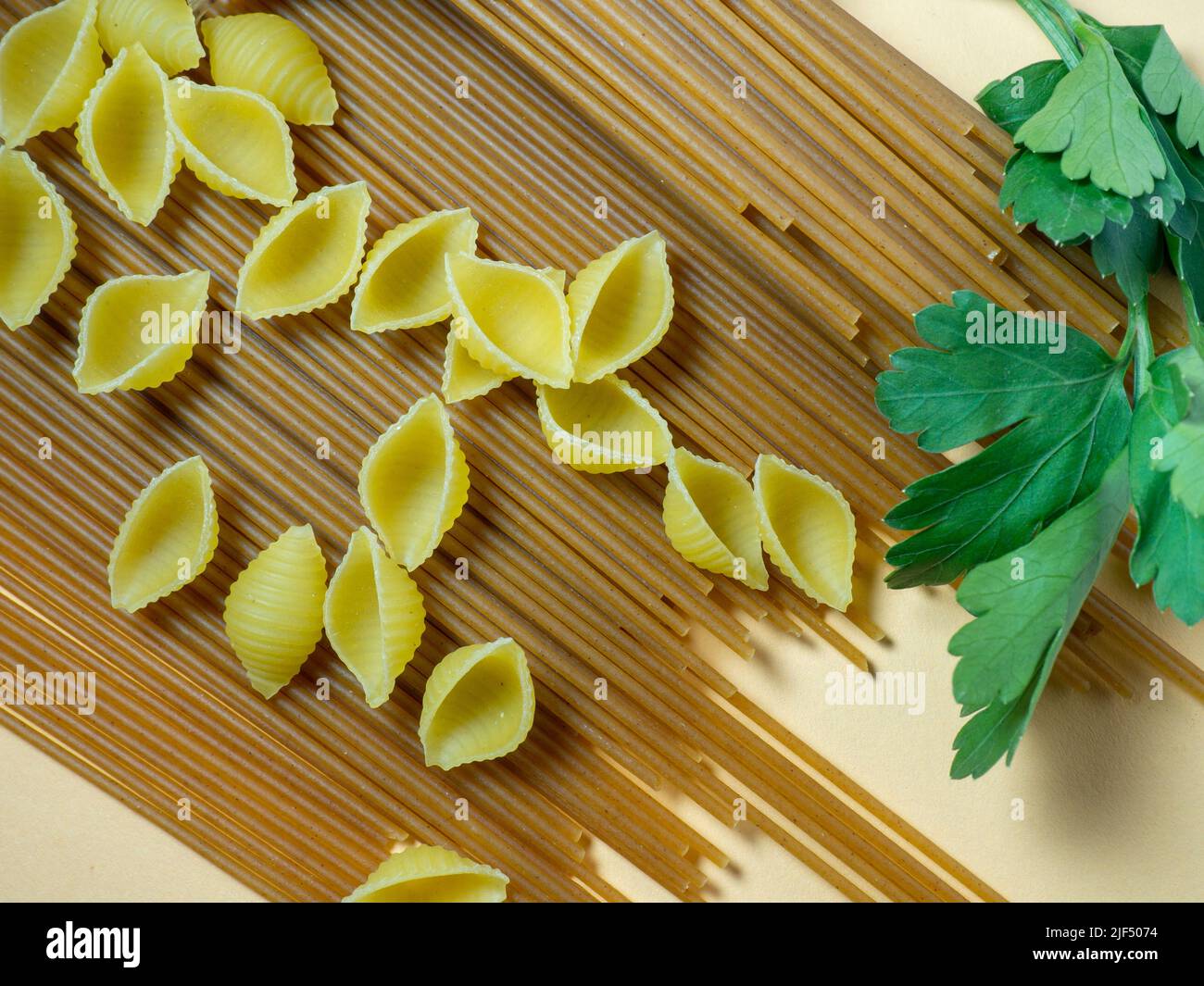 Shell Vs Spaghetti Spaghetti of two types on the table. shells and buckwheat pasta ...