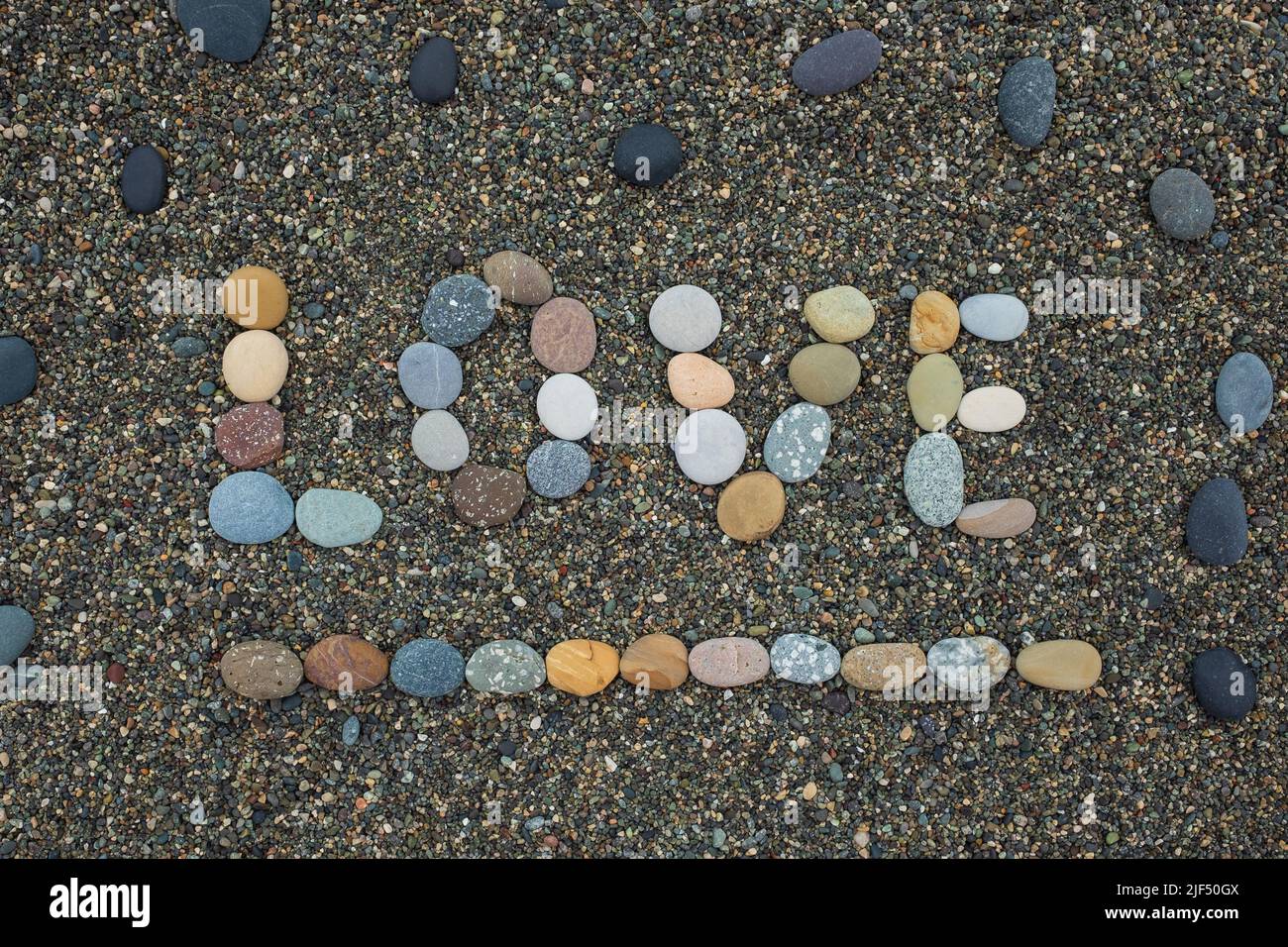 Word love made from stones on sandy beach. Romantic mood during vacation. Stock Photo