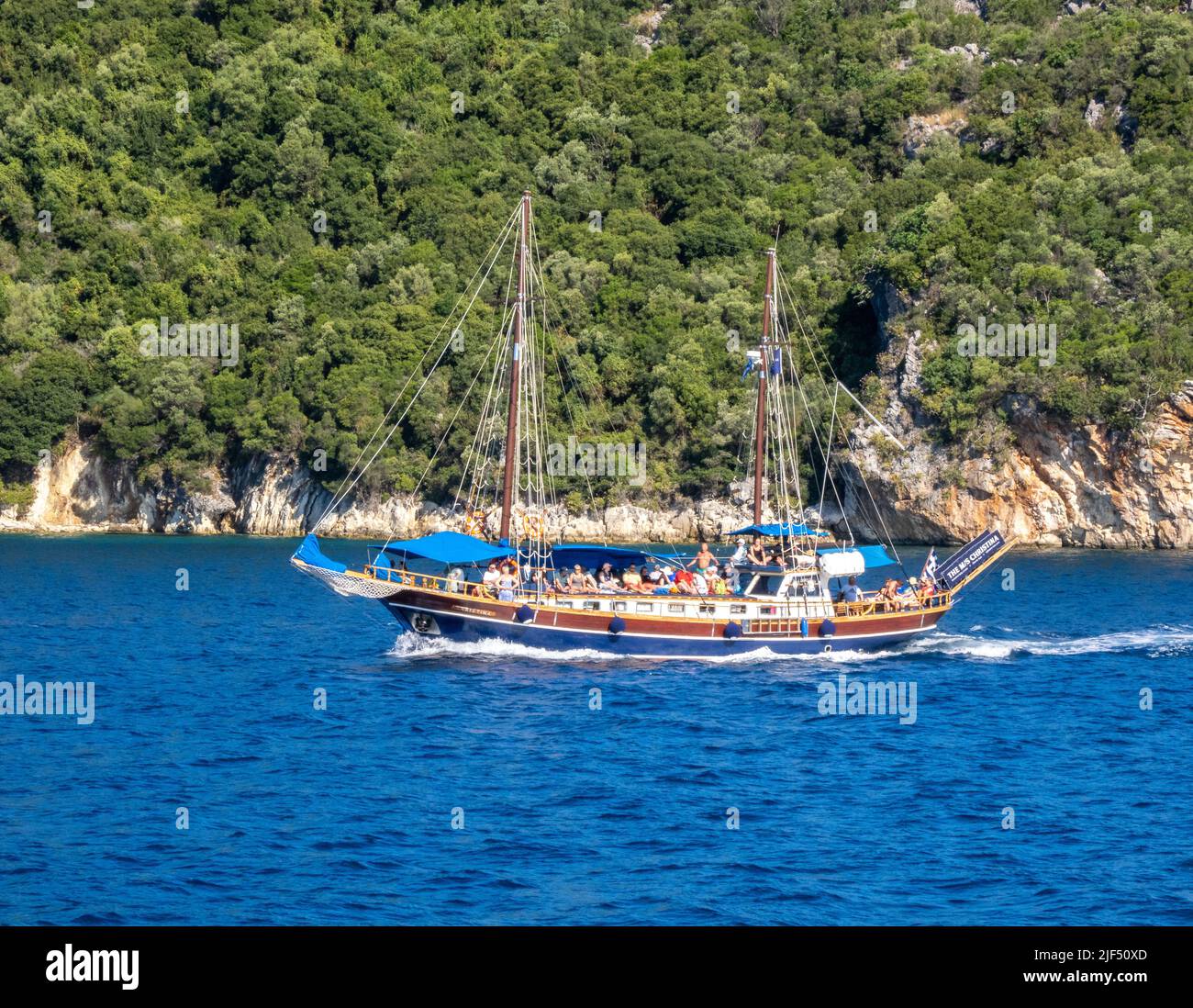 MS Christina sailing along the coast of Lefkada in the Ionian Islands of Greece with excited holiday day trippers visiting smaller islands Stock Photo