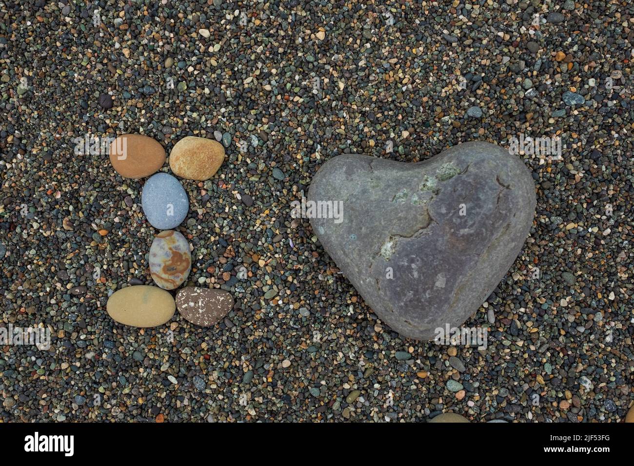 I love made from stones on sandy beach. Romantic mood during vacation. Stock Photo