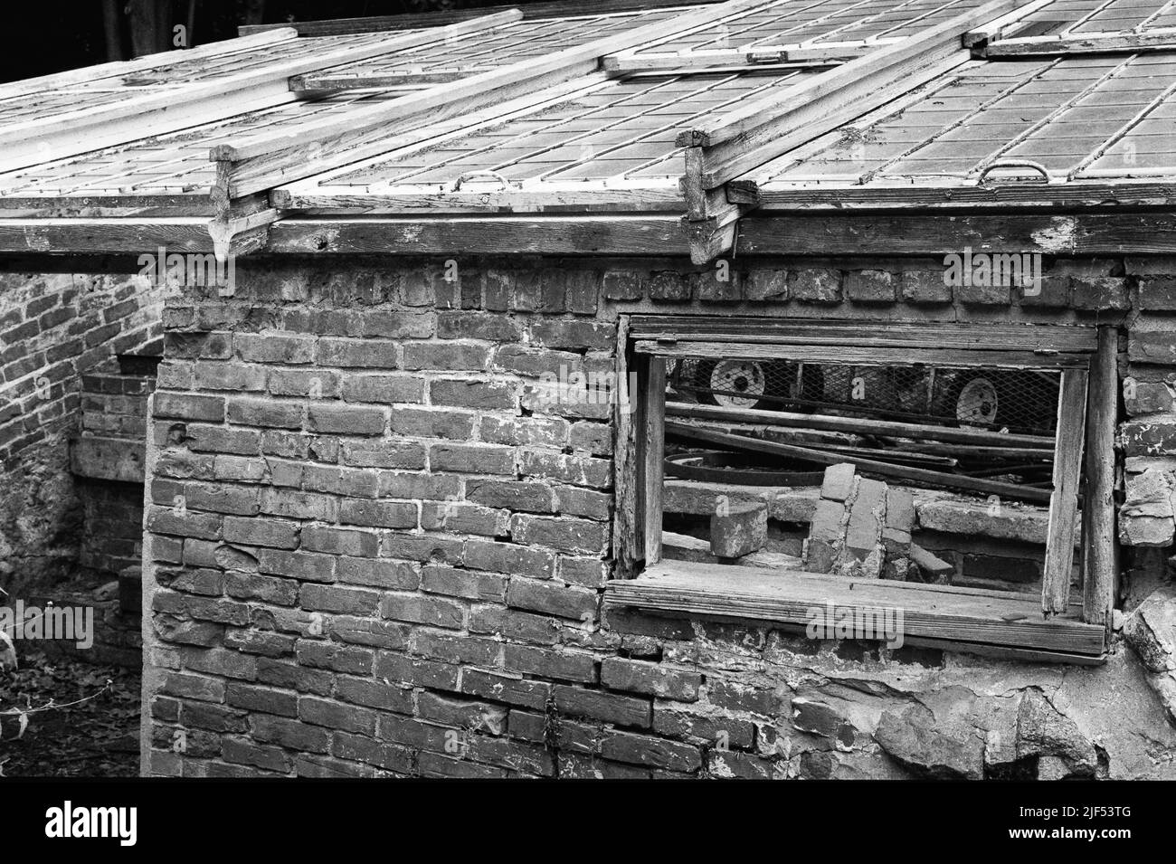 An old abandoned brick greenhouse in disrepair at the historic Lyman Estate home. Image captured on analog film. Waltham, Massachusetts USA. Stock Photo