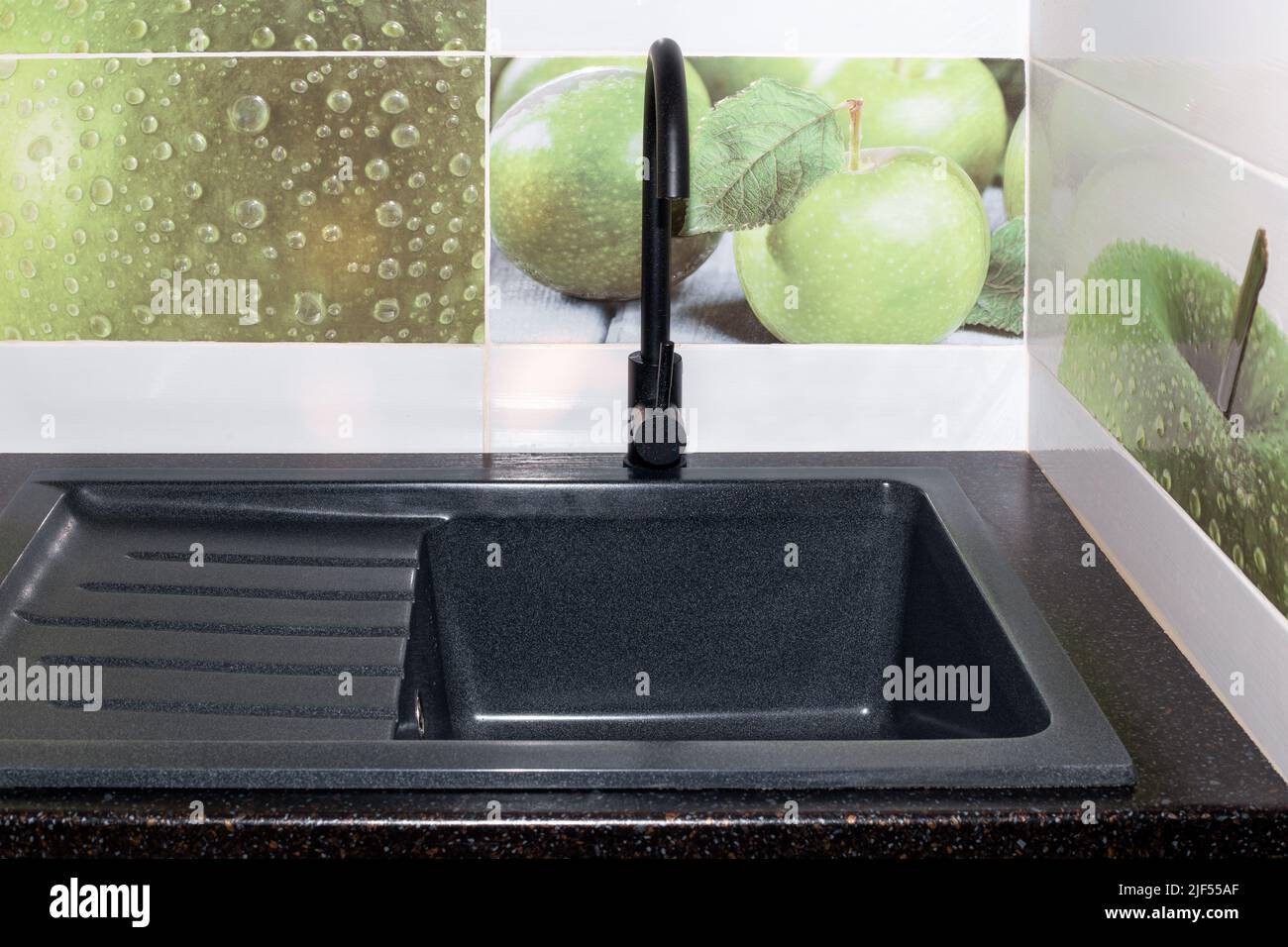 Kitchen sink and faucet installation. The black sink and faucet are