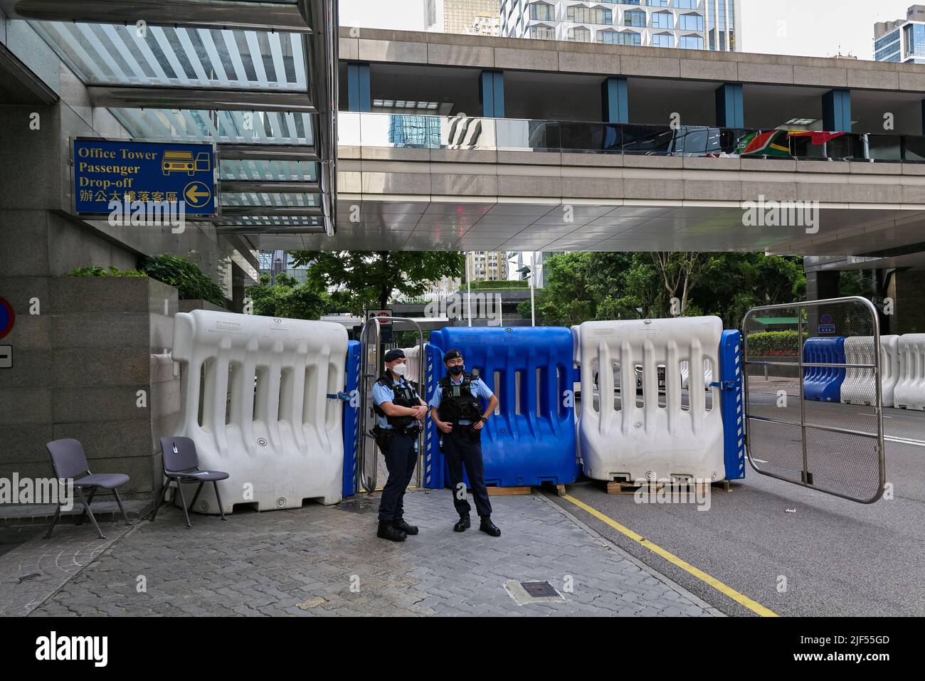 Two police officers stand on guard at the barrier outside the exhibition  center in Hong Kong's Wan Chai district for the 25th anniversary of Hong  Kong's return to the motherland. (Photo by