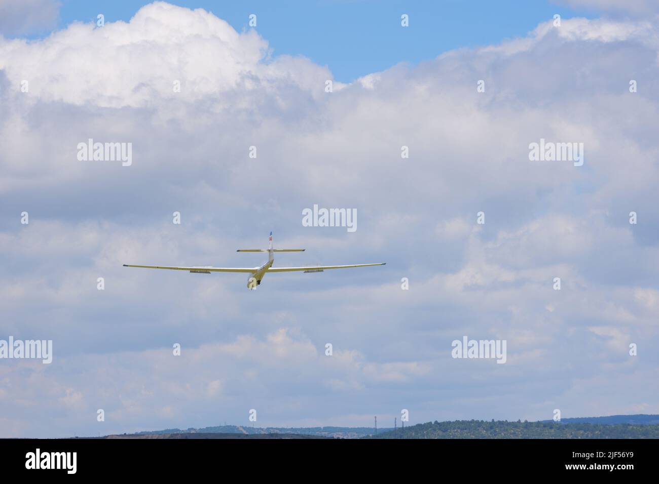 Glider flying away within clouds Stock Photo Alamy