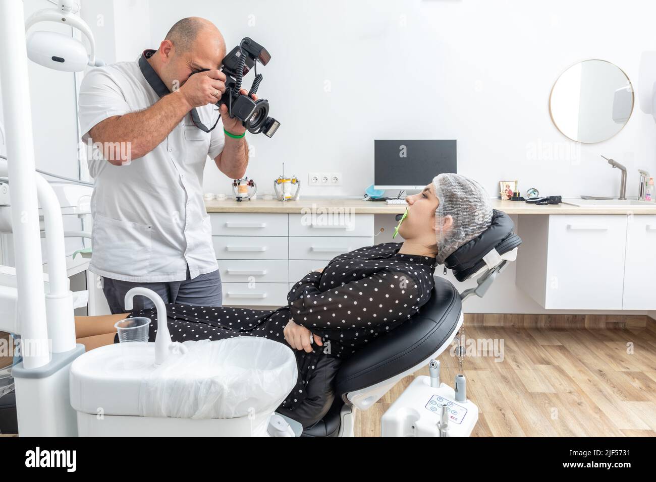 Dentist photographing patient's teeth for medical record before and after surgery in dentist