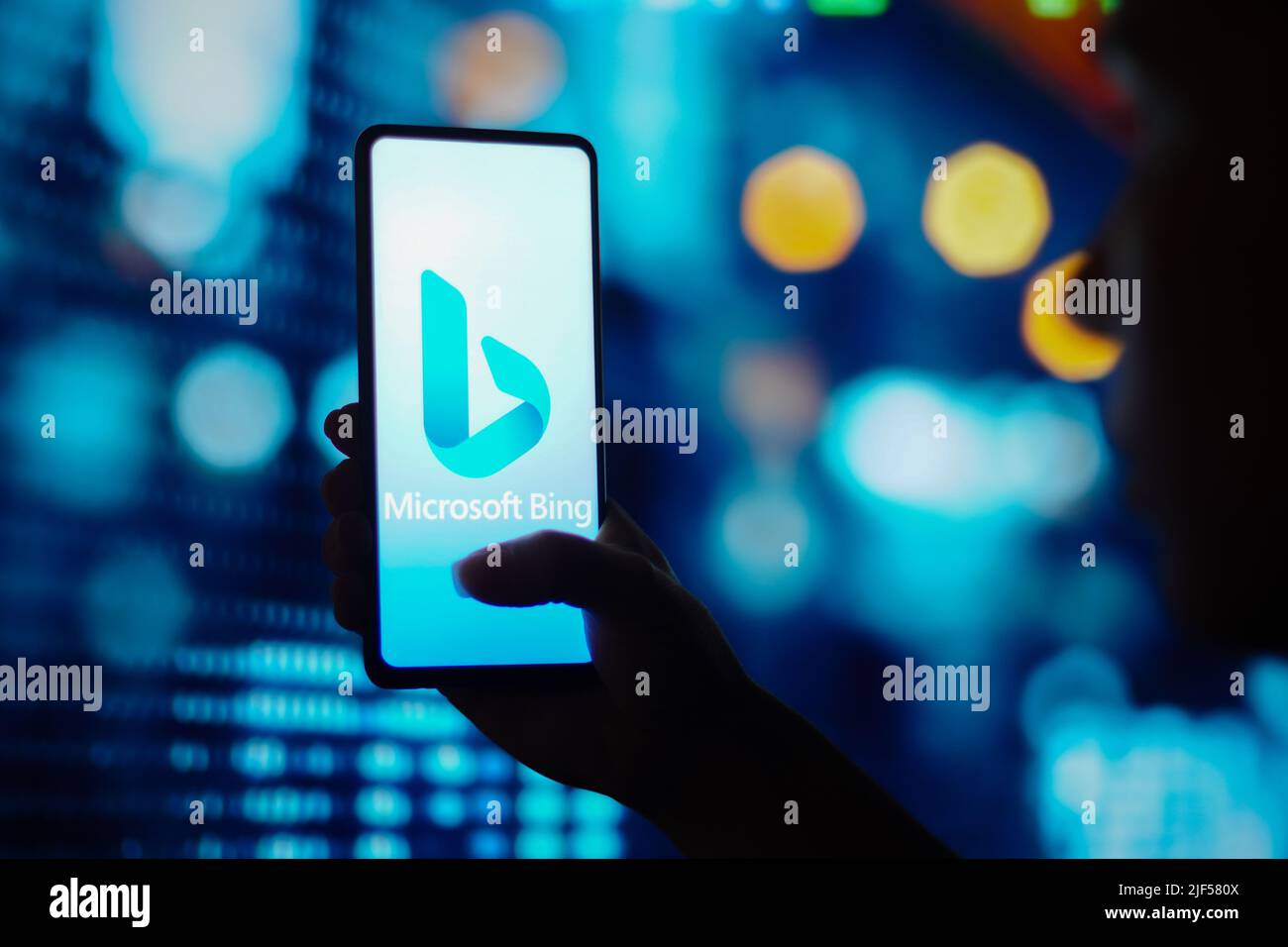 In this photo illustration, a silhouetted woman holds a smartphone with ...