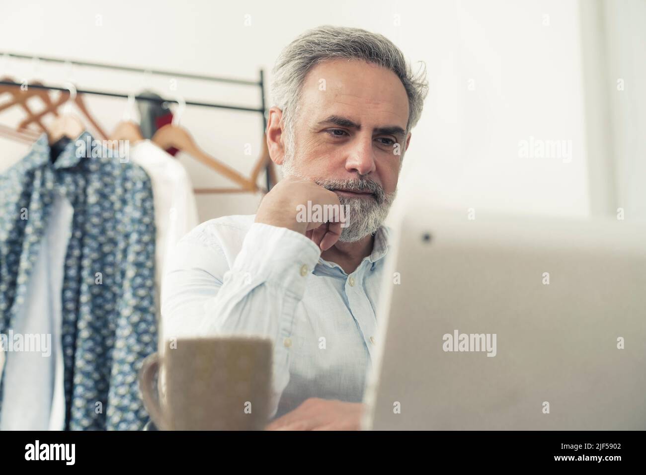 middle aged Caucasian man sits by the laptop copy space home background remote job concept . High quality photo Stock Photo