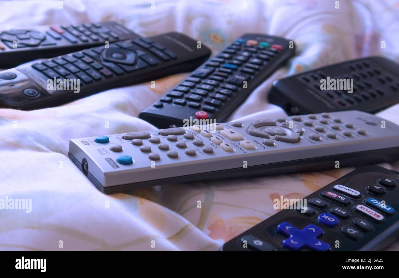 a couple of electronic remote controllers on the bed. Stock Photo