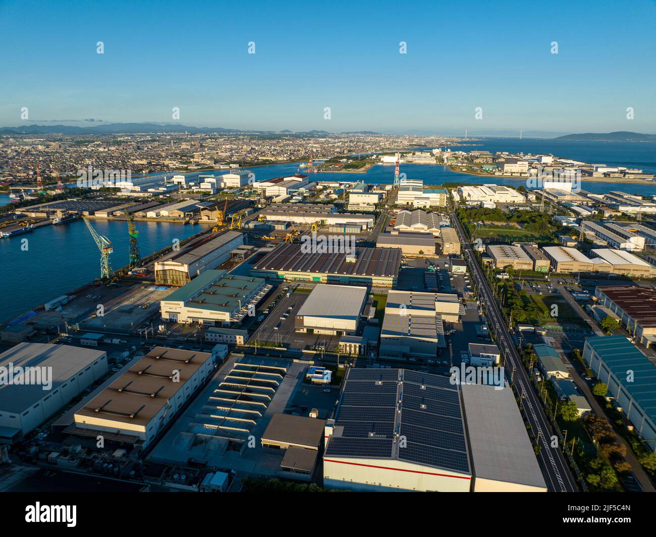 Aerial view of large cargo warehouses on manmade industrial island  Stock Photo