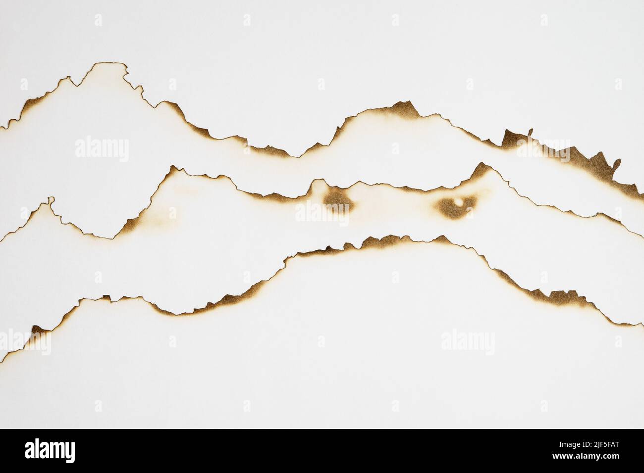 Stack of paper with burnt edges on white Stock Photo