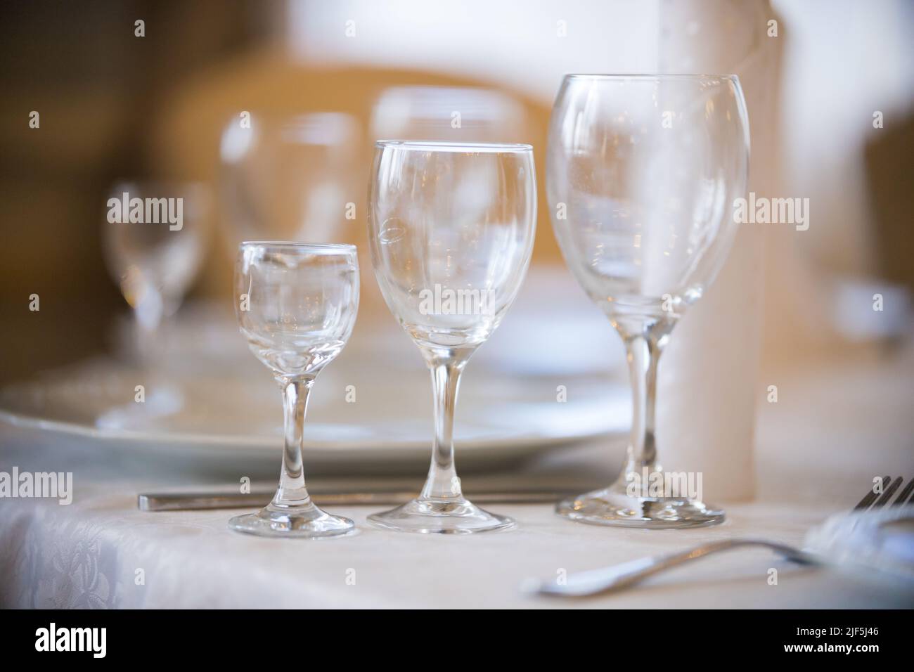 Light picture of empty glasses in restaurant - white plates. Mid shot Stock Photo