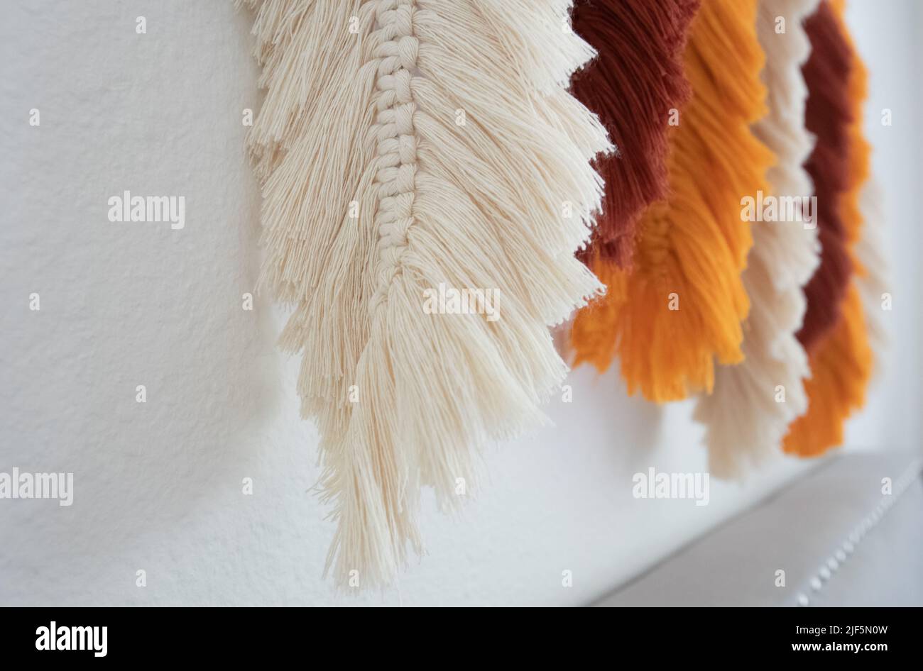 handmade boho wall decor macrame cotton rope feathers Stock Photo