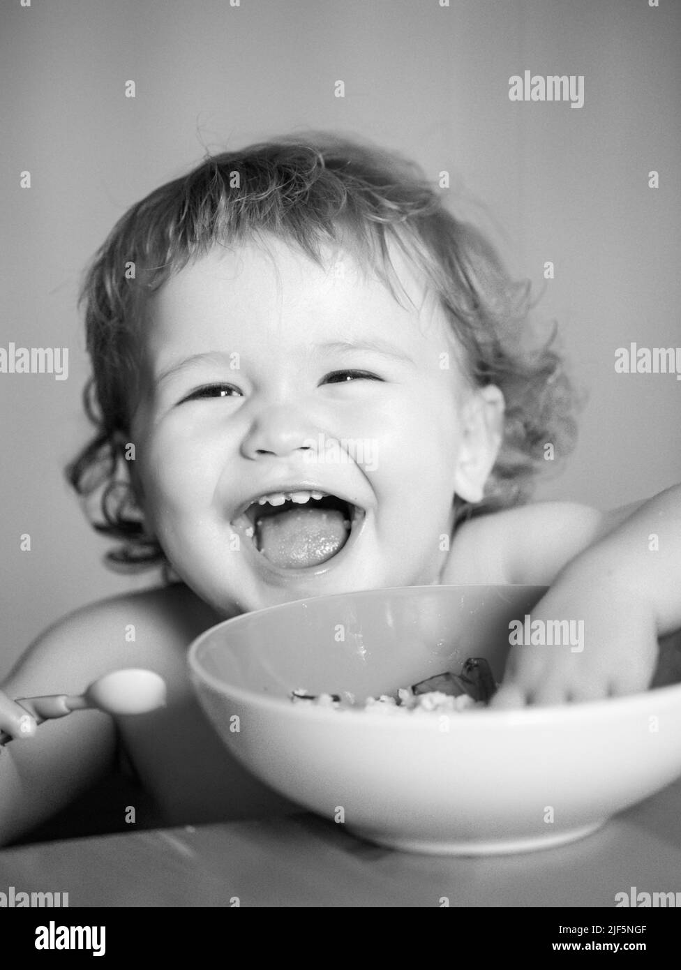 Launching child eat. Smiling baby eating food. Family, food, child ...