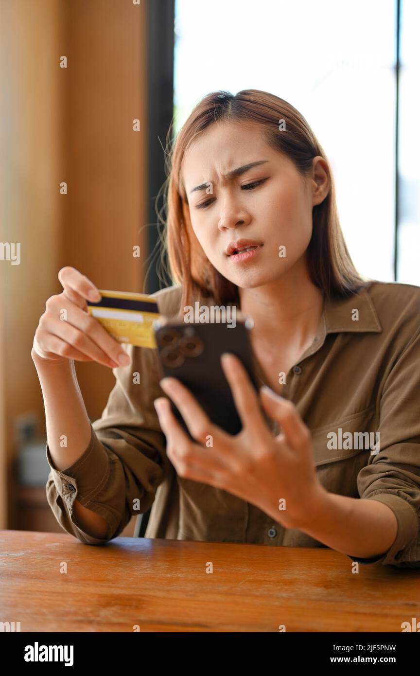 Mad and angry young Asian woman having a payment problem with her