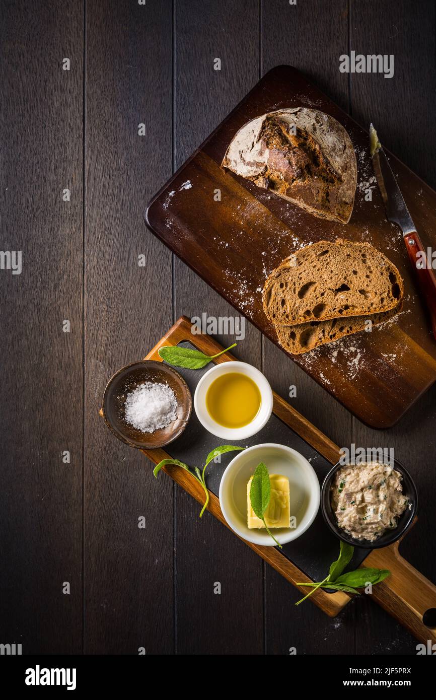 Spelt bread with homemade tuna spread, olive oil and salt on wooden background Stock Photo