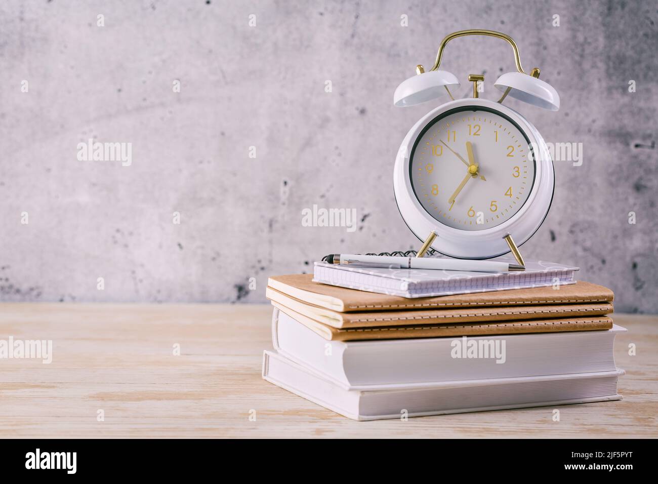Time managament concept for schoolers and students. Books with clock Stock Photo