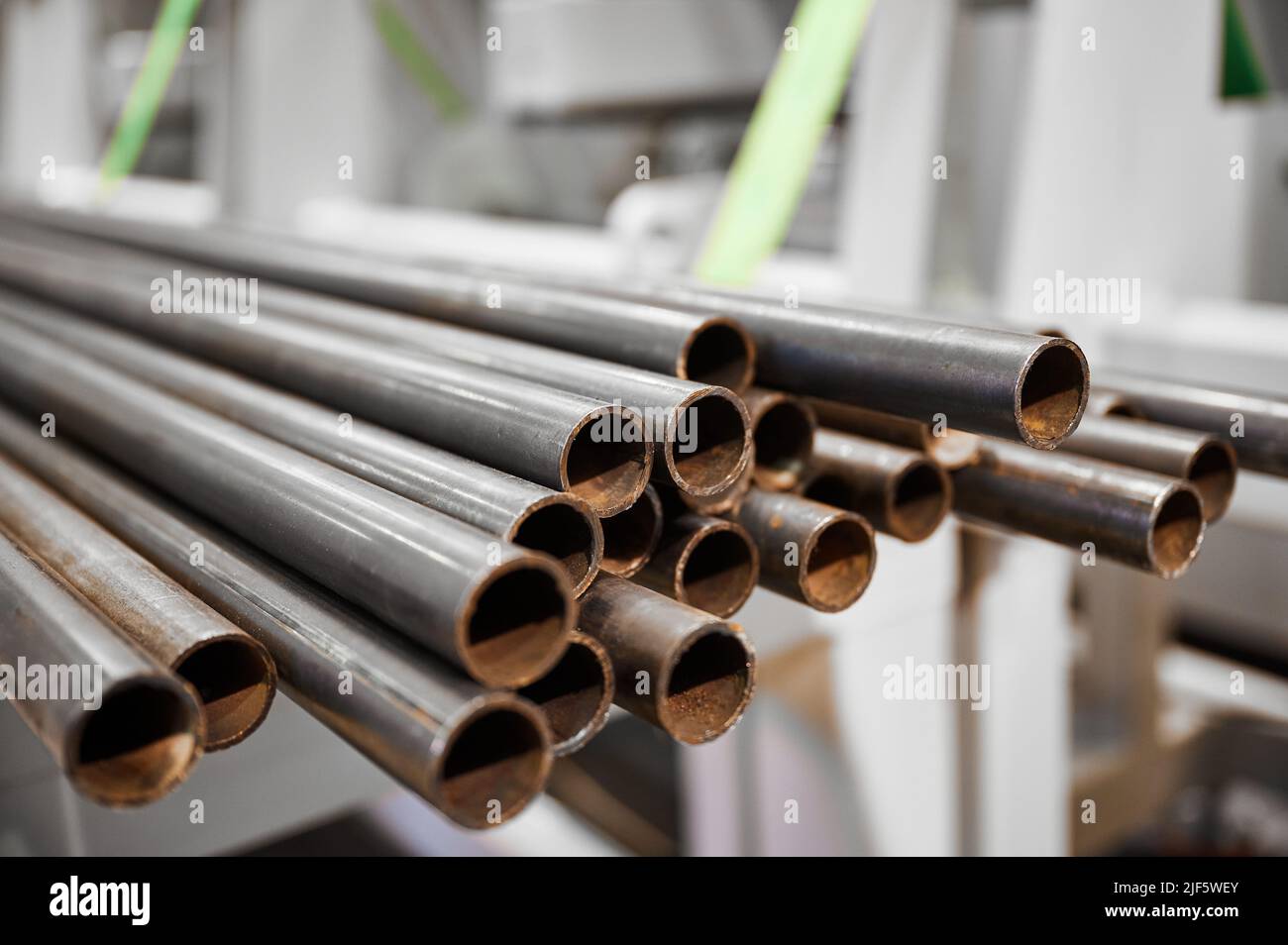 Stack of long metal pipes in metalworking plant warehouse Stock Photo