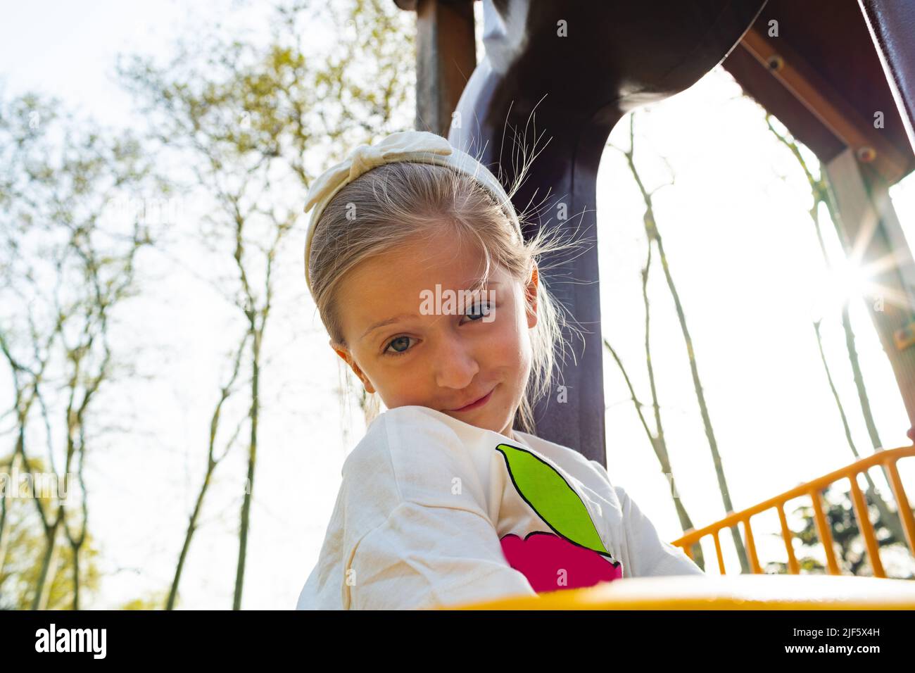 Active blonde little girl playing on a playground Stock Photo
