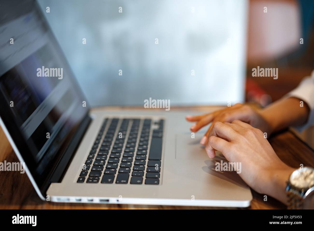 Close up of woman hands typing on laptop in cafe Stock Photo