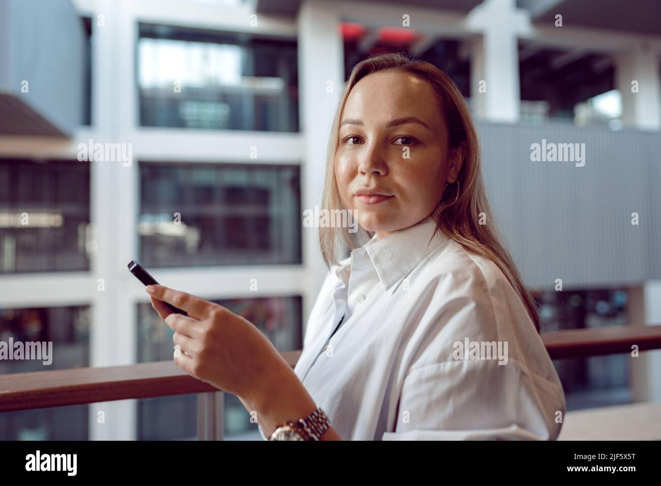 Businesswoman using her mobile phone in the balcony Stock Photo