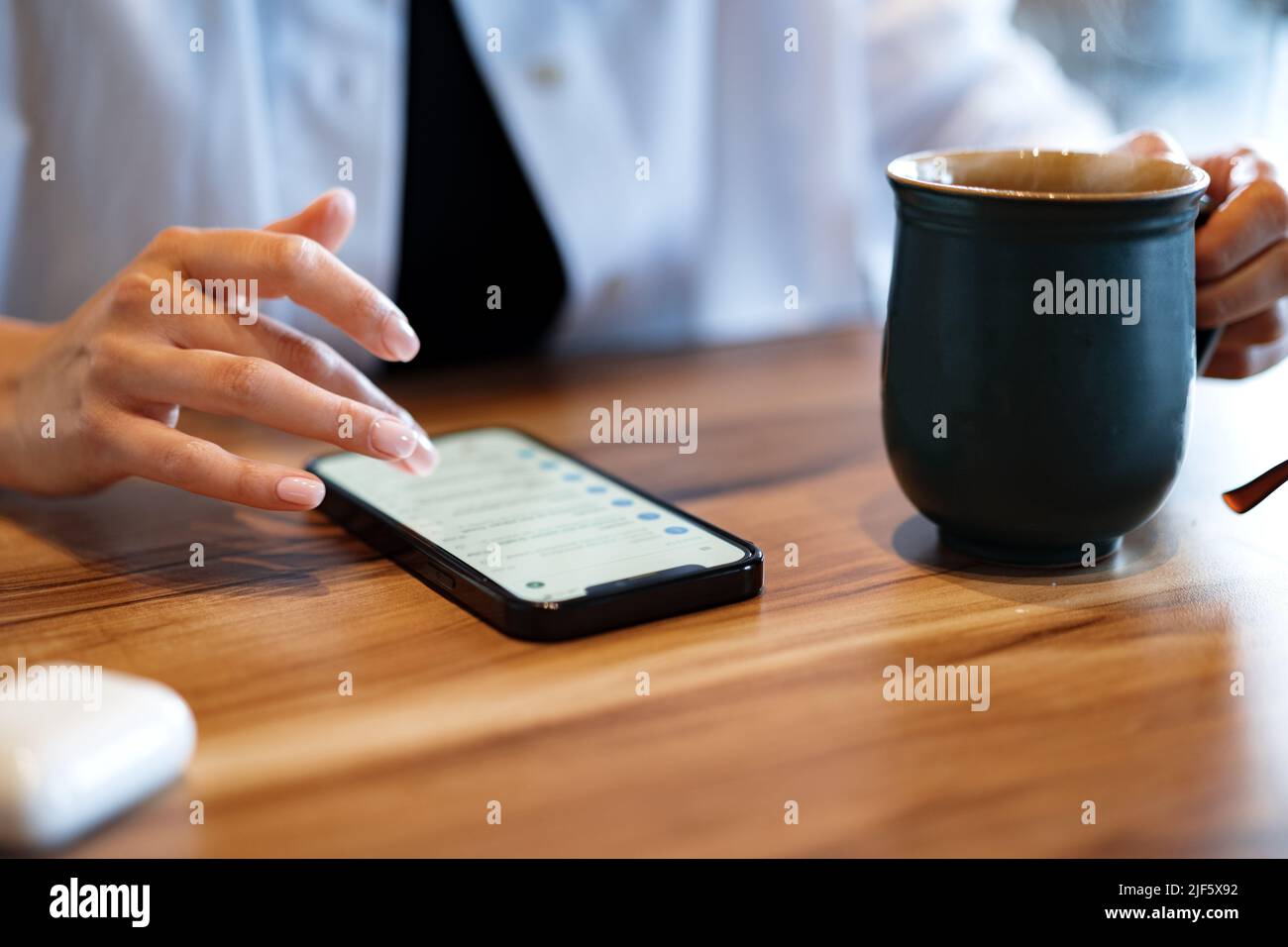 Close up of women's hands holding mobile phone with blank screen in cafe Stock Photo