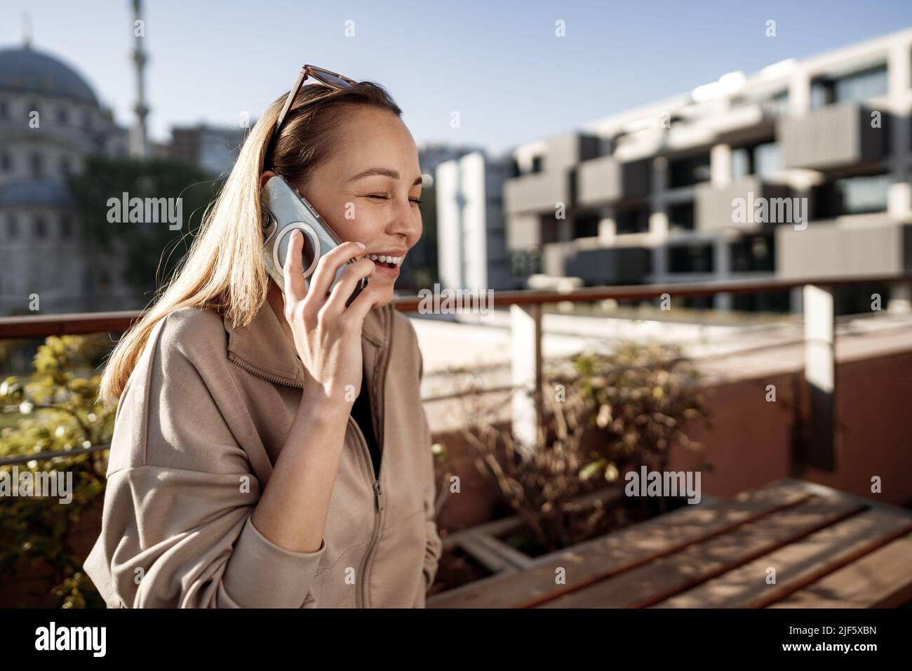 Portrait of beautiful young woman using smartphone on outdoor terrace in Istanbul Stock Photo