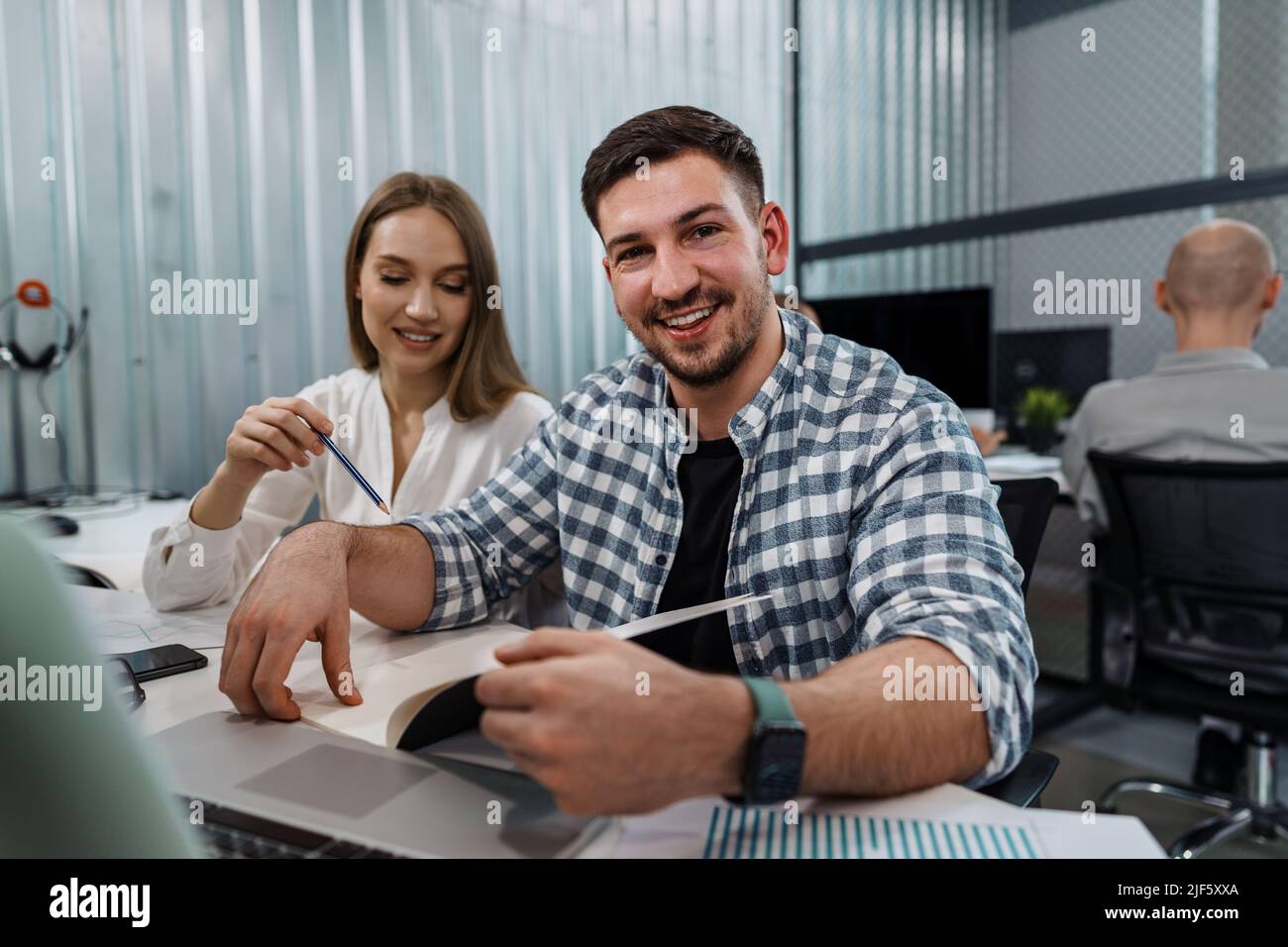 Two entrepreneurs man and woman sitting together working in an office Stock Photo