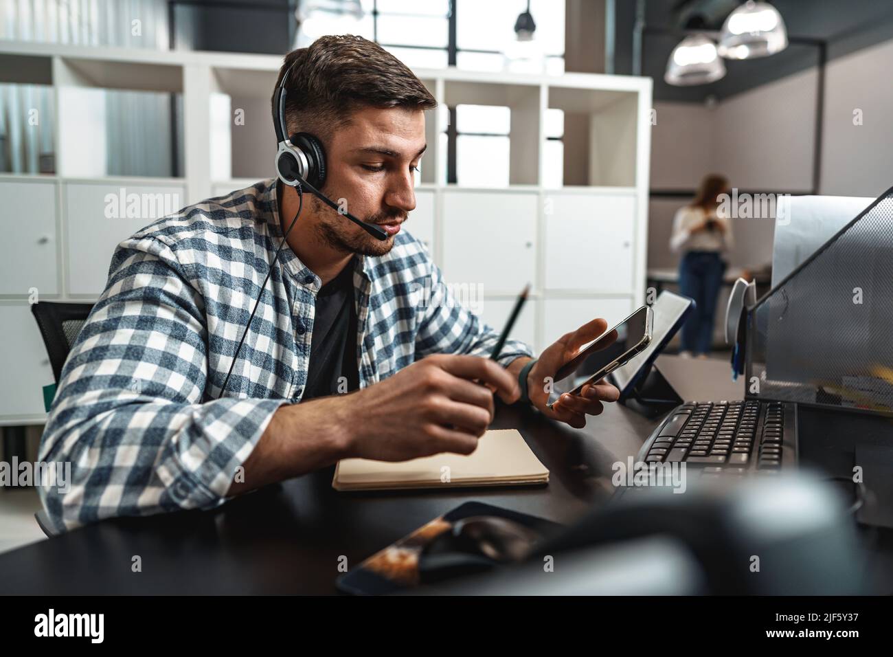 Customer service support operator man with headphones and microphone talking to client in call center Stock Photo