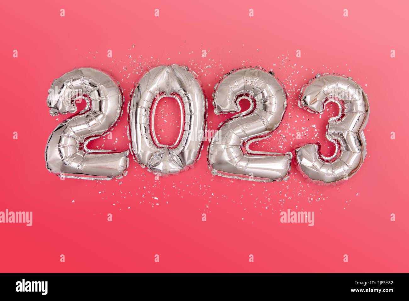 Silver foil balloons numeral 2023 and confetti Flat lay Stock Photo