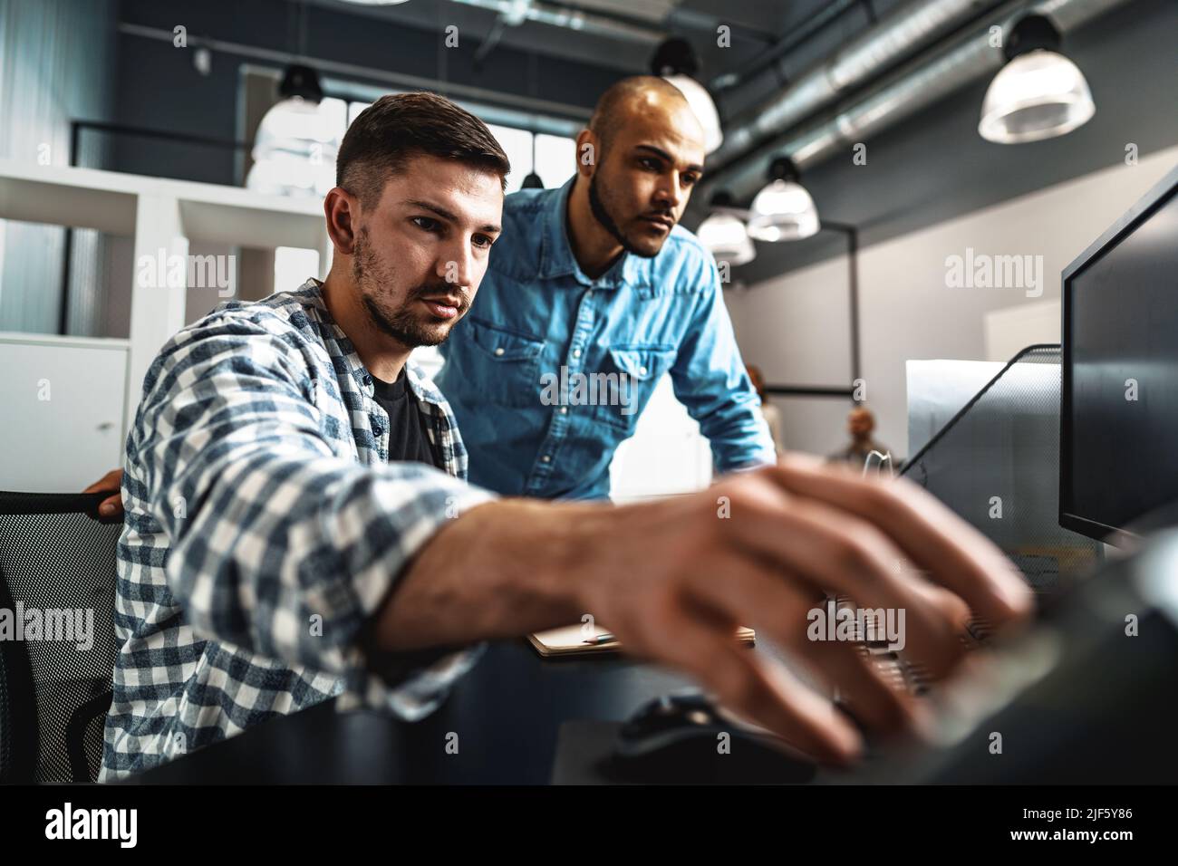 Two young men working together on a new business project in office Stock Photo