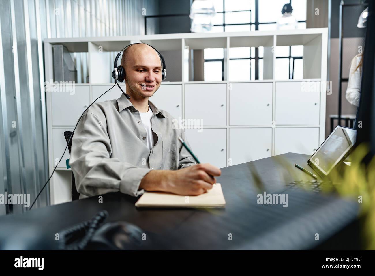 Young bald man working in a call center office Stock Photo