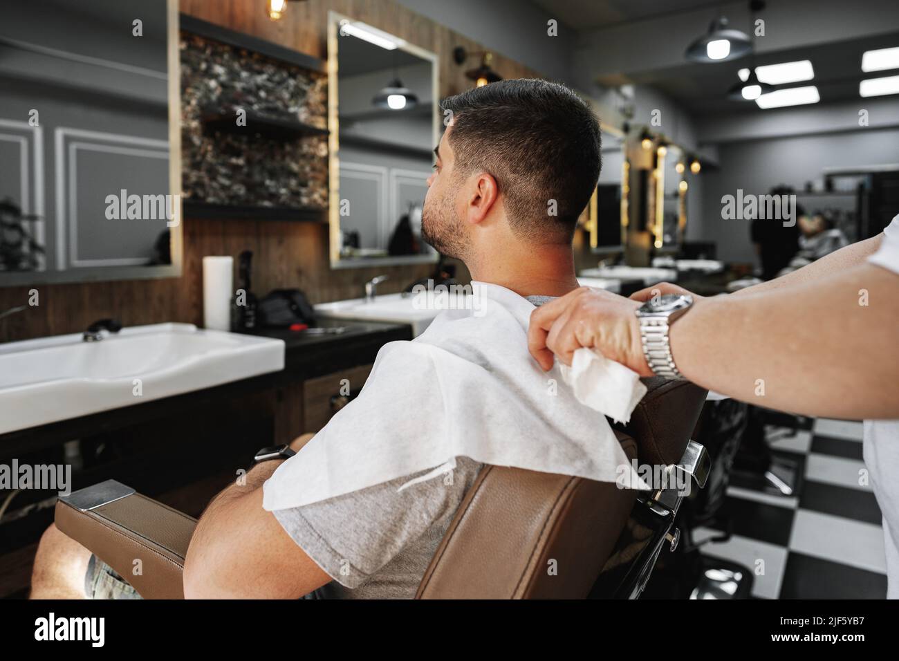 Young man client sitting in a barber shop Stock Photo