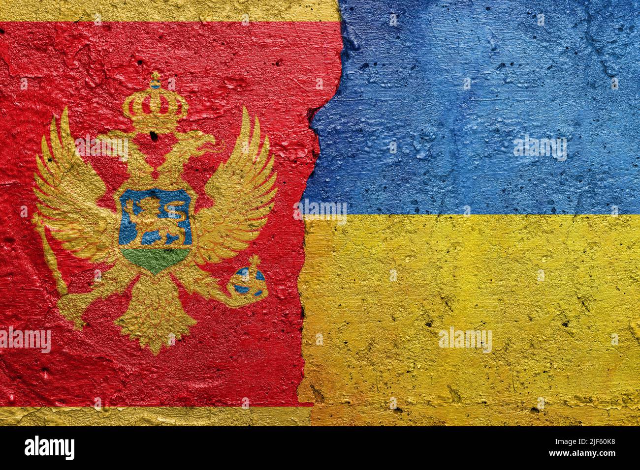 Montenegro and Ukraine - Cracked concrete wall painted with a Montenegrin flag on the left and a Ukrainian flag on the right Stock Photo