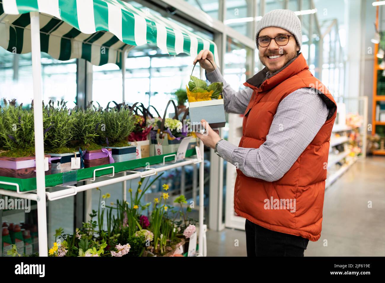 a man in a garden center chooses a potted plant for his home Stock ...