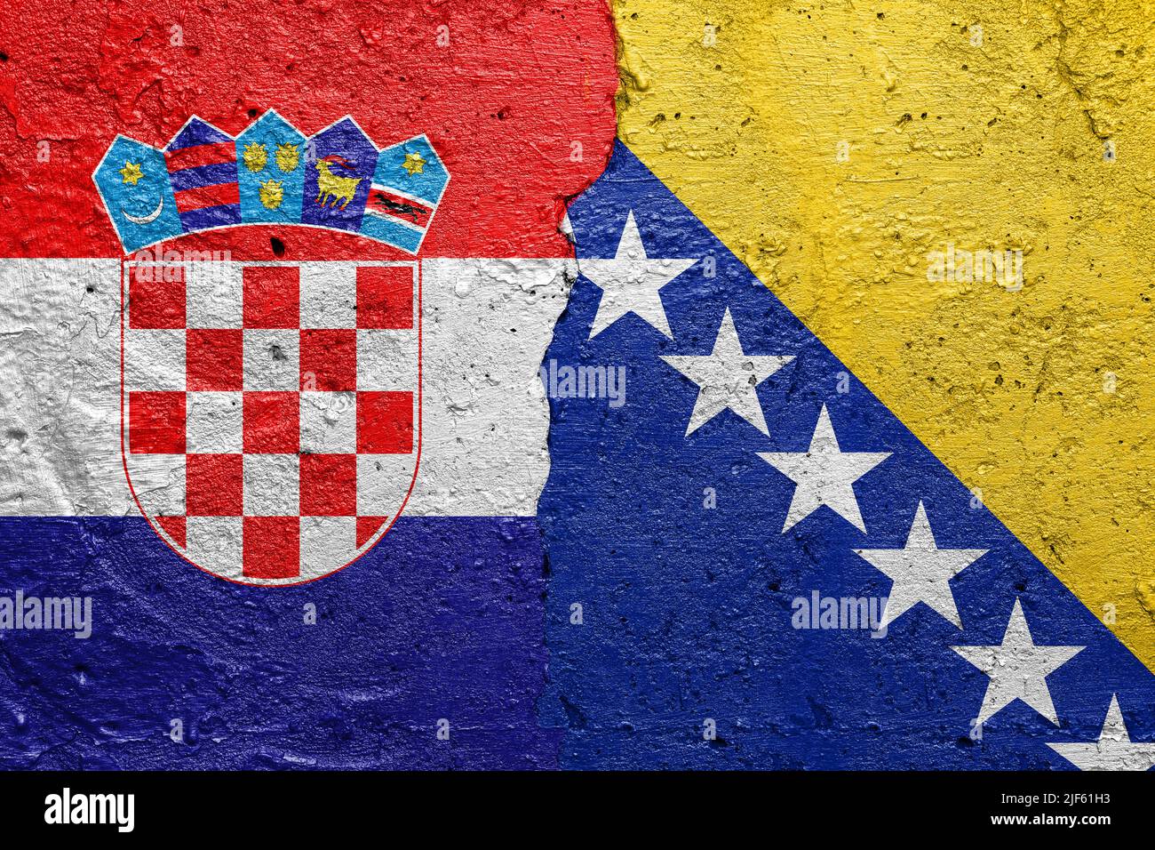 Croatia and Bosnia and Herzegovina - Cracked concrete wall painted with a Croatian flag on the left and a Bosnian flag on the right Stock Photo
