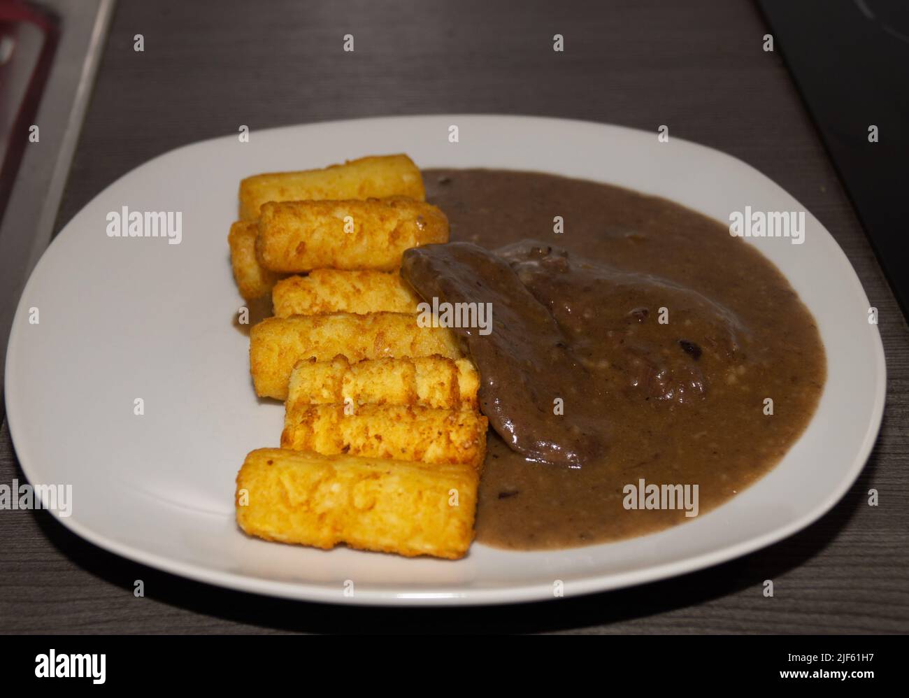 Rehschnitzel in Rotweinsauce mit Kroketten Stock Photo - Alamy
